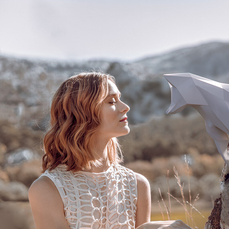 Kobieta rozmyśla nad swoją intuicją na świeżym powietrzu wpatrując się w lisa